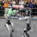 People watch humanoid robots boxing at an exhibition during the World Artificial Intelligence Conference in Shanghai on July 26, 2025